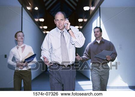 Portrait of a businesspeople walking in a corridor View Large Photo Image Stock Photograph - Portrait of a businesspeople walking in a corridor. Fotosearch