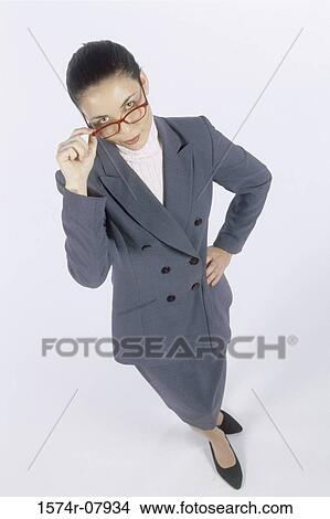 Picture - Portrait of a businesswoman adjusting her eyeglasses. Fotosearch