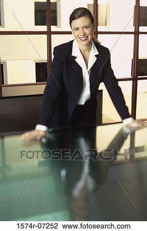 Portrait of a businesswoman leaning on a table smiling View Large Photo Image Stock Image - Portrait of a businesswoman leaning on a table smiling. Fotosearch