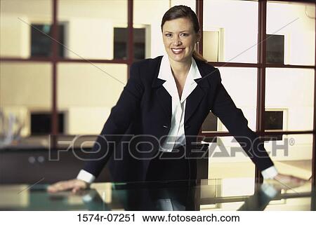 Portrait of a businesswoman leaning against a table smiling View Large Photo Image Stock Image - Portrait of a businesswoman leaning against a table smiling. Fotosearch