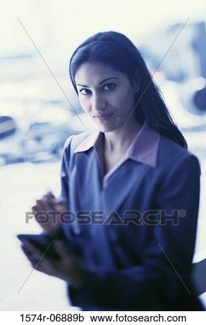 Portrait of a businesswoman operating a hand held device View Large Photo Image Stock Image - Portrait of a businesswoman operating a hand held device. Fotosearch