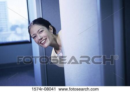 Portrait of a businesswoman peeking from behind a doorway smiling View Large Photo Image Stock Image - Portrait of a businesswoman peeking from behind a doorway smiling. Fotosearch