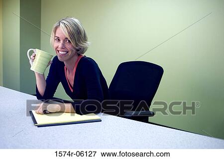 Stock Photo - Portrait of a businesswoman sitting in an office holding a coffee mug. Fotosearch