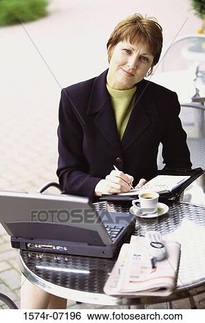 Portrait of a businesswoman sitting in front of a laptop View Large Photo Image Stock Photograph - Portrait of a businesswoman sitting in front of a laptop. Fotosearch