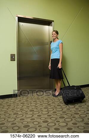 Stock Image - Portrait of a businesswoman standing near an elevator. Fotosearch