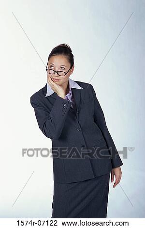 Stock Image - Portrait of a Businesswoman standing with her hand on her chin. Fotosearch