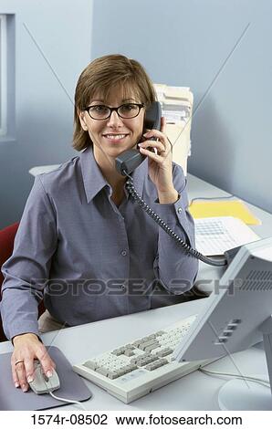 Stock Image - Portrait of a businesswoman talking on a telephone. Fotosearch