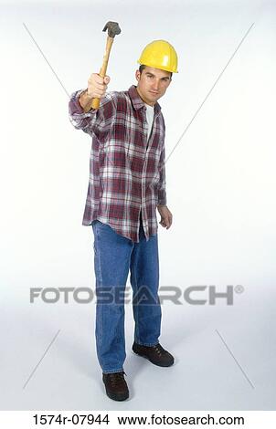 Portrait of a construction worker holding out a hammer View Large Photo Image Picture - Portrait of a construction worker holding out a hammer. Fotosearch