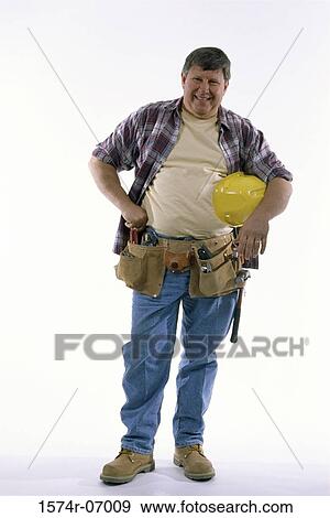 Stock Photo - Portrait of a construction worker holding a hardhat. Fotosearch