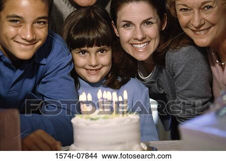 Portrait of a family smiling in front of a cake View Large Photo Image Picture - Portrait of a family smiling in front of a cake. Fotosearch