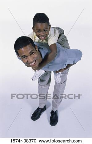 Stock Image - Portrait of a father carrying his son on his back. Fotosearch