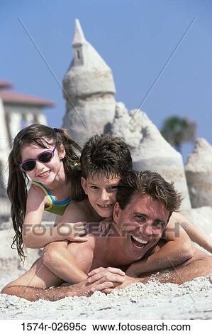 Portrait of a father lying on the beach with his son and daughter View Large Photo Image Stock Image - Portrait of a father lying on the beach with his son and daughter. Fotosearch