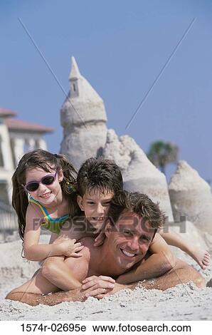 Portrait of a father lying on the beach with his son and daughter View Large Photo Image Stock Image - Portrait of a father lying on the beach with his son and daughter. Fotosearch