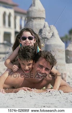 Portrait of a father lying on the beach with his son and daughter View Large Photo Image Stock Image - Portrait of a father lying on the beach with his son and daughter. Fotosearch