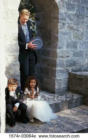 Stock Image - Portrait of a flower girl sitting with a ring bearer. Fotosearch