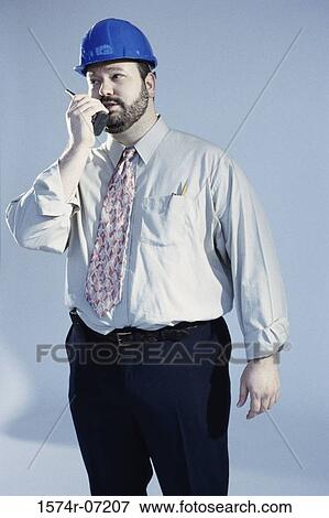 Stock Photo - Portrait of a foreman talking on a walkie-talkie. Fotosearch