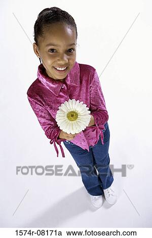 Portrait of a girl holding a flower View Large Photo Image Stock Image - Portrait of a girl holding a flower. Fotosearch