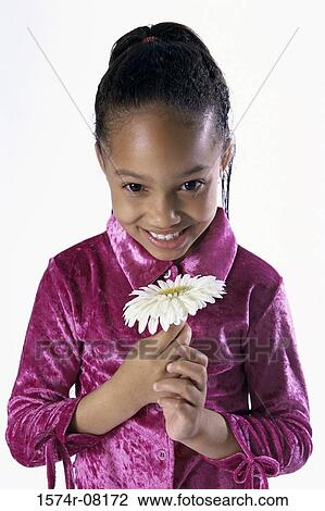 Stock Image - Portrait of a girl holding a flower. Fotosearch