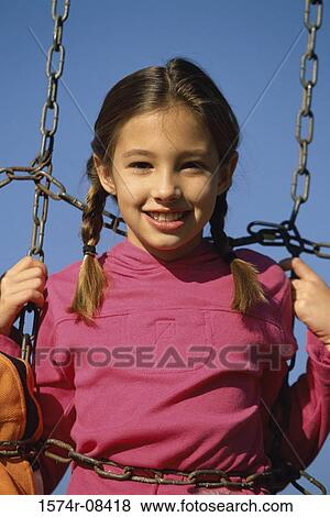 Portrait of a girl holding onto chains View Large Photo Image Stock Photo - Portrait of a girl holding onto chains. Fotosearch