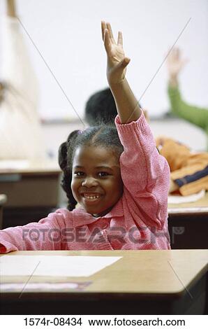 Picture - Portrait of a girl raising her hand in class. Fotosearch