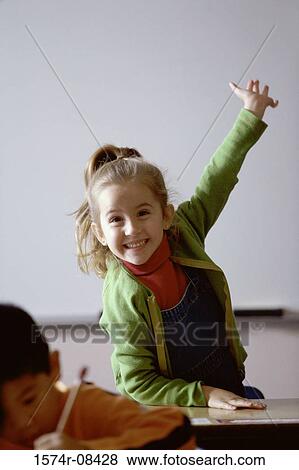 Portrait of a girl raising her hand in class View Large Photo Image Stock Photo - Portrait of a girl raising her hand in class. Fotosearch