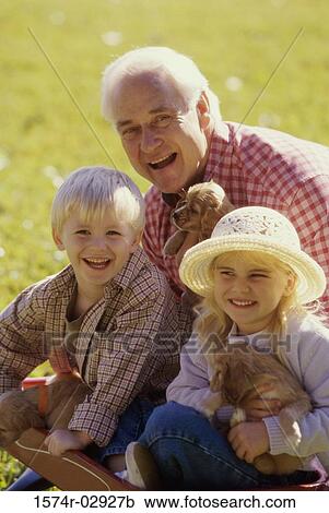Portrait of a grandfather with his grandson and granddaughter holding puppies View Large Photo Image Stock Image - Portrait of a grandfather with his grandson and granddaughter holding puppies. Fotosearch