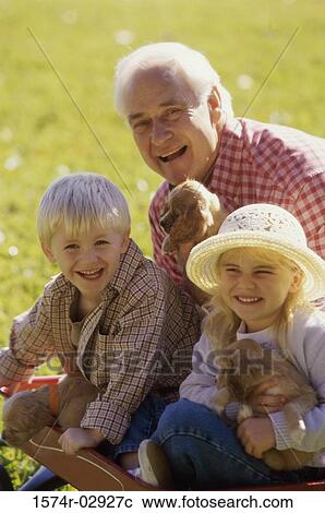 Portrait of a grandfather with his grandson and granddaughter holding puppies View Large Photo Image Stock Image - Portrait of a grandfather with his grandson and granddaughter holding puppies. Fotosearch