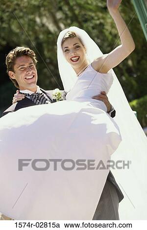 Portrait of a groom lifting his bride View Large Photo Image Stock Image - Portrait of a groom lifting his bride. Fotosearch