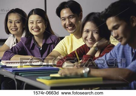 Stock Image - Portrait of a group of teenagers in a classroom. Fotosearch