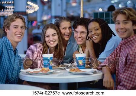 Stock Image - Portrait of a group of teenagers sitting in a restaurant. Fotosearch