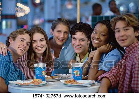 Portrait of a group of teenagers sitting in a restaurant View Large Photo Image Stock Image - Portrait of a group of teenagers sitting in a restaurant. Fotosearch