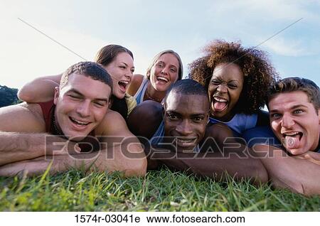 Portrait of a group of young people lying on grass View Large Photo Image Stock Image - Portrait of a group of young people lying on grass. Fotosearch