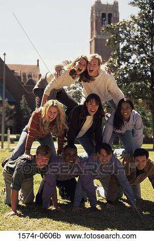 Stock Image - Portrait of a group of young people making a human pyramid. Fotosearch