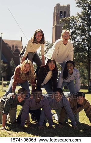Stock Image - Portrait of a group of young people making a human pyramid. Fotosearch