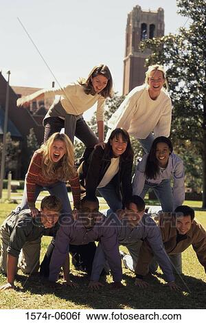 Stock Image - Portrait of a group of young people making a human pyramid. Fotosearch