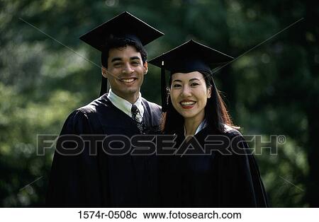Stock Image - Portrait of a male graduate and a female graduate. Fotosearch