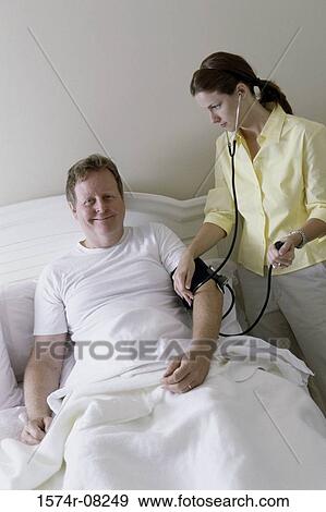 Portrait of a male patient getting examined by a female nurse View Large Photo Image Stock Photo - Portrait of a male patient getting examined by a female nurse. Fotosearch