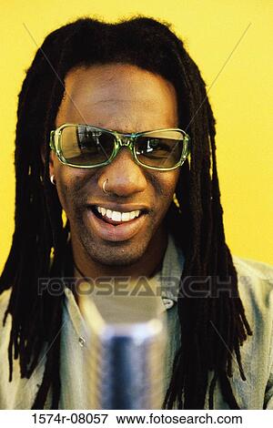 Portrait of a man singing into a microphone View Large Photo Image Stock Photo - Portrait of a man singing into a microphone. Fotosearch