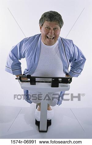 Portrait of a man standing on a scale View Large Photo Image Stock Image - Portrait of a man standing on a scale. Fotosearch