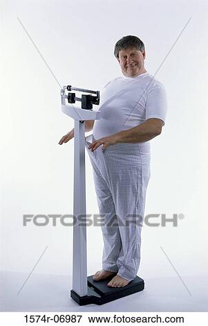 Portrait of a man standing on a scale View Large Photo Image Stock Photo - Portrait of a man standing on a scale. Fotosearch