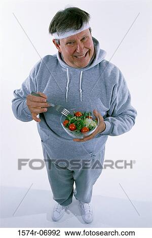 Portrait of a mid adult man holding a salad bowl and a fork View Large Photo Image Stock Image - Portrait of a mid adult man holding a salad bowl and a fork. Fotosearch