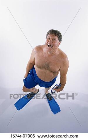 Stock Photograph - Portrait of a mid adult man in shorts wearing flippers. Fotosearch