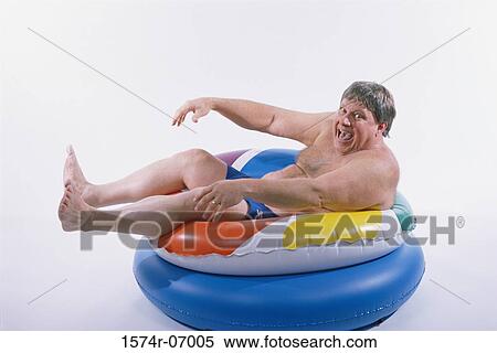 Portrait of a mid adult man sitting on an inflatable ring View Large Photo Image Stock Photography - Portrait of a mid adult man sitting on an inflatable ring. Fotosearch