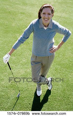 Portrait of a mid adult woman standing on a golf course View Large Photo Image Stock Image - Portrait of a mid adult woman standing on a golf course. Fotosearch