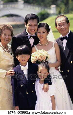 Portrait of a newlywed couple standing with their parents View Large Photo Image Stock Image - Portrait of a newlywed couple standing with their parents. Fotosearch