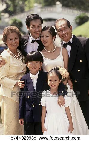 Portrait of a newlywed couple standing with their parents View Large Photo Image Stock Image - Portrait of a newlywed couple standing with their parents. Fotosearch