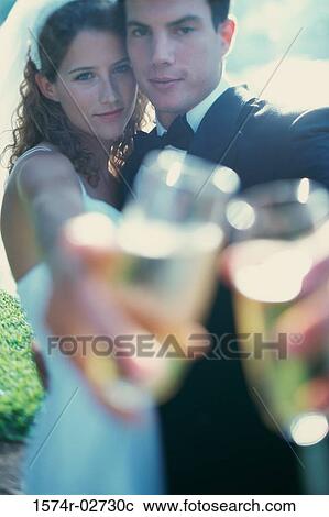 Stock Image - Portrait of a newlywed couple toasting with glasses of champagne. Fotosearch