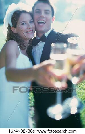 Portrait of a newlywed couple toasting with glasses of champagne View Large Photo Image Stock Image - Portrait of a newlywed couple toasting with glasses of champagne. Fotosearch