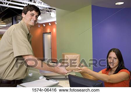 Portrait of a receptionist receiving a package from a delivery man View Large Photo Image Stock Photograph - Portrait of a receptionist receiving a package from a delivery man. Fotosearch