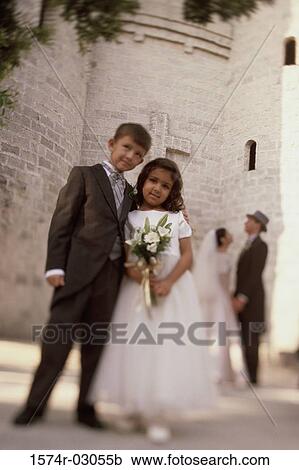 Portrait of a ring bearer and a flower girl standing in front of a church View Large Photo Image Stock Image - Portrait of a ring bearer and a flower girl standing in front of a church. Fotosearch